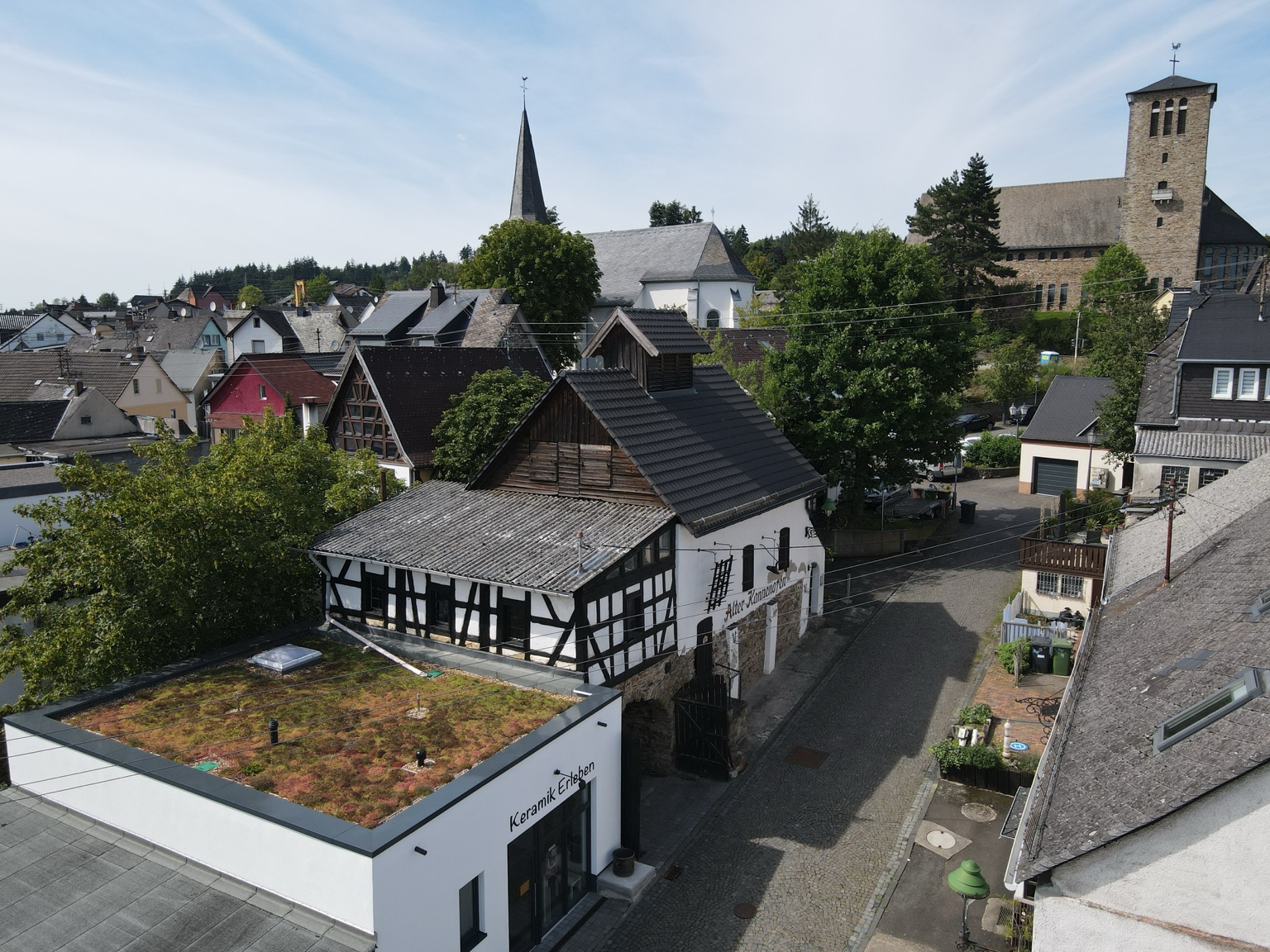 Museum und Alter Kannenofen in Ransbach-Baumbach, dahinter links die evangelische und rechts die katholische Kirche. Aufnahme von Bernd Hammer.